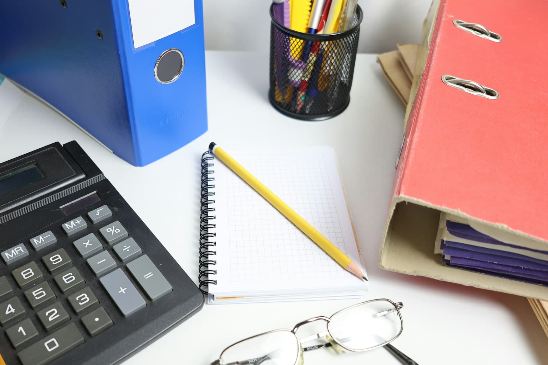 Escritorio de trabajo contable con calculadora, carpetas y cuaderno